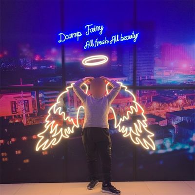 Des ailes d'ange et un panneau au néon décorant une fête avec des lettres de marquise